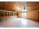 Large living room with wood ceiling, ceiling fans, and ample built-in shelves with cabinet space at 10244 Washington Blvd, Carmel, IN 46280