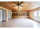 Expansive living room with wood-paneled ceiling, ceiling fans, built-in shelving, and hardwood flooring at 10244 Washington Blvd, Carmel, IN 46280