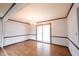Open living area with chandelier lighting, wood floors, and a sliding glass door at 10244 Washington Blvd, Carmel, IN 46280