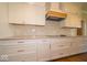 Stylish kitchen showcasing white cabinets, granite countertops, and a tiled backsplash above the cooktop at 10586 Jacks Way, Indianapolis, IN 46234