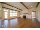 Bright living room featuring wood floors, beams, a fireplace, and large windows with a view to the outside at 10586 Jacks Way, Indianapolis, IN 46234