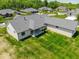 Aerial view of the home's rear, featuring a covered patio and expansive green lawn at 10586 Jacks Way, Indianapolis, IN 46234