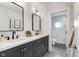 Modern bathroom with dual sinks, matte black hardware, and access to a toilet room at 10673 Misty Hollow Ln, Fishers, IN 46038