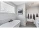 Elegant bathroom featuring a soaking tub with hexagon tile surround and modern fixtures at 10673 Misty Hollow Ln, Fishers, IN 46038