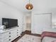 Cozy bedroom with dark hardwood floors, closet with sliding doors, and simple furnishings at 10673 Misty Hollow Ln, Fishers, IN 46038