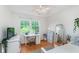 Bright bedroom with a large window, hardwood floors and a white desk area at 10673 Misty Hollow Ln, Fishers, IN 46038