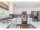 Bright kitchen with stainless appliances, white cabinets, and gray backsplash tiles at 10673 Misty Hollow Ln, Fishers, IN 46038