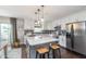 Modern kitchen boasts stainless appliances, a large island with seating, and sleek white cabinets at 10673 Misty Hollow Ln, Fishers, IN 46038