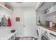 Organized laundry room featuring washer, dryer, storage shelves and a convenient bench at 10673 Misty Hollow Ln, Fishers, IN 46038