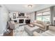 Comfortable living room with a fireplace, plush seating, and natural lighting at 10673 Misty Hollow Ln, Fishers, IN 46038