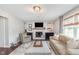 Cozy living room with a brick fireplace, comfortable furniture, and large windows at 10673 Misty Hollow Ln, Fishers, IN 46038