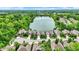 Aerial view of homes by a lake showcasing community layout, mature trees, and landscaping at 1071 Serenity Ct, Carmel, IN 46280