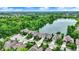 Aerial view of homes near a lake, trees and distant buildings highlighting the community's proximity to city amenities at 1071 Serenity Ct, Carmel, IN 46280