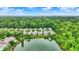 Aerial view of lakeside homes surrounded by lush green trees under a partly cloudy sky at 1071 Serenity Ct, Carmel, IN 46280