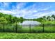 Backyard view featuring a fenced-in area with a scenic lake view and lush greenery at 1071 Serenity Ct, Carmel, IN 46280