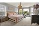 Luxurious bedroom featuring a king-size bed, elegant chandelier, and large windows offering picturesque outdoor views at 1071 Serenity Ct, Carmel, IN 46280