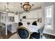 Bright kitchen with white cabinets, an island with seating, and a cozy dining nook at 1071 Serenity Ct, Carmel, IN 46280