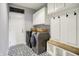 Modern laundry room with front-load washer and dryer, complemented by storage cabinets and a convenient bench at 1071 Serenity Ct, Carmel, IN 46280