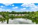 Backyard view of cozy lakeside houses surrounded by lush green trees under a partly cloudy sky at 1071 Serenity Ct, Carmel, IN 46280