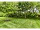 Beautifully landscaped backyard with lush green grass, mature trees, and well-maintained lawn at 10888 Weston Dr, Carmel, IN 46032