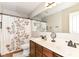 Bathroom with double sink vanity, floral shower curtain, and tile floor at 10888 Weston Dr, Carmel, IN 46032