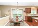 Cozy dining area with hardwood floors, adjacent to kitchen featuring a large window at 10888 Weston Dr, Carmel, IN 46032