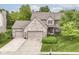 Aerial view of a brick home with a well-maintained lawn, mature trees, and a spacious driveway at 10888 Weston Dr, Carmel, IN 46032