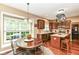 Open-concept kitchen with wooden cabinets, a central island, and a sunlit dining area by a large window at 10888 Weston Dr, Carmel, IN 46032