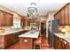 Well-lit kitchen boasts stainless steel appliances, wooden cabinetry, and a functional central island with barstool seating at 10888 Weston Dr, Carmel, IN 46032