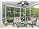 Cozy screened porch with comfortable seating, ceiling fan, and views of the lush backyard at 10888 Weston Dr, Carmel, IN 46032