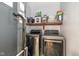 Convenient laundry room with modern washer and dryer units, and storage shelving at 1135 W Wildflower Ct, Mooresville, IN 46158