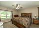 Comfortable main bedroom with a ceiling fan, large window, and wood furniture at 1135 W Wildflower Ct, Mooresville, IN 46158