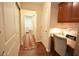 Hallway with hardwood floors, built-in desk, and access to laundry area with natural light at 1150 Extraordinary Trl, Greenfield, IN 46140