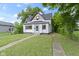 Charming two-story home with black roof, white siding and inviting front yard with green grass at 1150 W 30Th St, Indianapolis, IN 46208