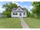 Charming two-story home with black roof, white siding and inviting landscaped front yard at 1150 W 30Th St, Indianapolis, IN 46208