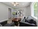 Bright open-concept living room featuring modern gray furniture, white shelves, stainless appliances in kitchen at 1150 W 30Th St, Indianapolis, IN 46208