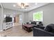 Open-concept living room features modern gray furniture, a ceiling fan and a large picture window at 1150 W 30Th St, Indianapolis, IN 46208