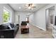 Open-concept living room features modern gray furniture, a ceiling fan and a large picture window at 1150 W 30Th St, Indianapolis, IN 46208
