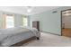 Bedroom with two windows, light green walls, soft carpet, ceiling fan, and closet access at 11807 Rolling Springs Dr, Carmel, IN 46033