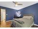 A full bed in a room with hardwood flooring, blue walls, and a ceiling fan at 11807 Rolling Springs Dr, Carmel, IN 46033
