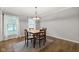 Bright dining room with hardwood floors, a modern chandelier and natural light at 11807 Rolling Springs Dr, Carmel, IN 46033