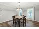Bright dining room with hardwood floors, a modern chandelier and two windows at 11807 Rolling Springs Dr, Carmel, IN 46033