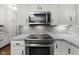Updated kitchen featuring white cabinets, granite countertops, and stainless steel microwave and oven at 11807 Rolling Springs Dr, Carmel, IN 46033
