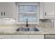 Stainless steel sink with granite countertop and white cabinetry offer a clean and functional kitchen space at 11807 Rolling Springs Dr, Carmel, IN 46033