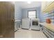 Laundry room featuring washer, dryer, and charming blue wallpaper at 11807 Rolling Springs Dr, Carmel, IN 46033