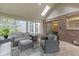 Relaxing sunroom featuring brick wall, skylight, and comfortable seating, creating an inviting space at 11807 Rolling Springs Dr, Carmel, IN 46033