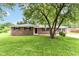 Charming single-story brick home with a well-manicured lawn and shade tree at 12029 Meadow Ln, Indianapolis, IN 46236
