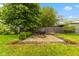 Backyard featuring a patio with a fire pit, surrounded by lush greenery and mature trees at 1211 W 10Th St, Muncie, IN 47302