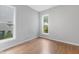 Bright bedroom with two windows, light gray walls, and new, warm-toned laminate flooring throughout at 1211 W 10Th St, Muncie, IN 47302