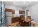 Compact kitchen with wood cabinets, stainless steel appliances, and a cozy dining area at 1211 W 10Th St, Muncie, IN 47302